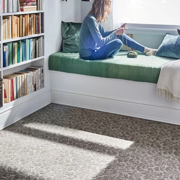 girl reading in a bedroom with white furniture and light brown carpet from May's Lone Star Flooring on Atlanta, TX area